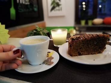 Zdjęcie przedstawia filiżankę kawy i porcję ciasta w restauracji Chwas Prast