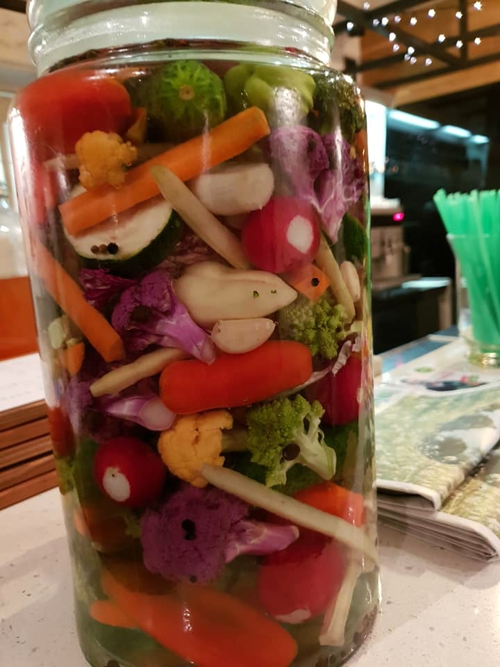 Zdjęcie przedstawia słój wypełniony kiszonymi warzywami