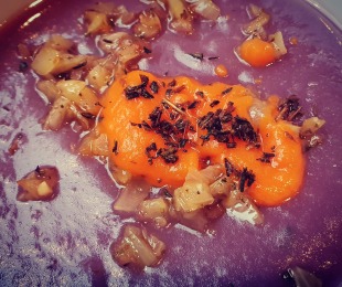 Zdjęcie przedstawia talerz kremu z fioletowych ziemniaków z jaśminowym musem dyniowym