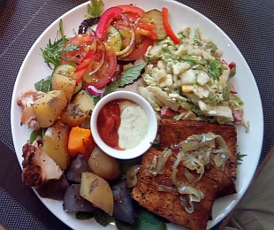 Zdjęcie przedstawia Polędwiczki sojowe podane z pieczonymi ziemniakami, surówką, warzywami i sosami